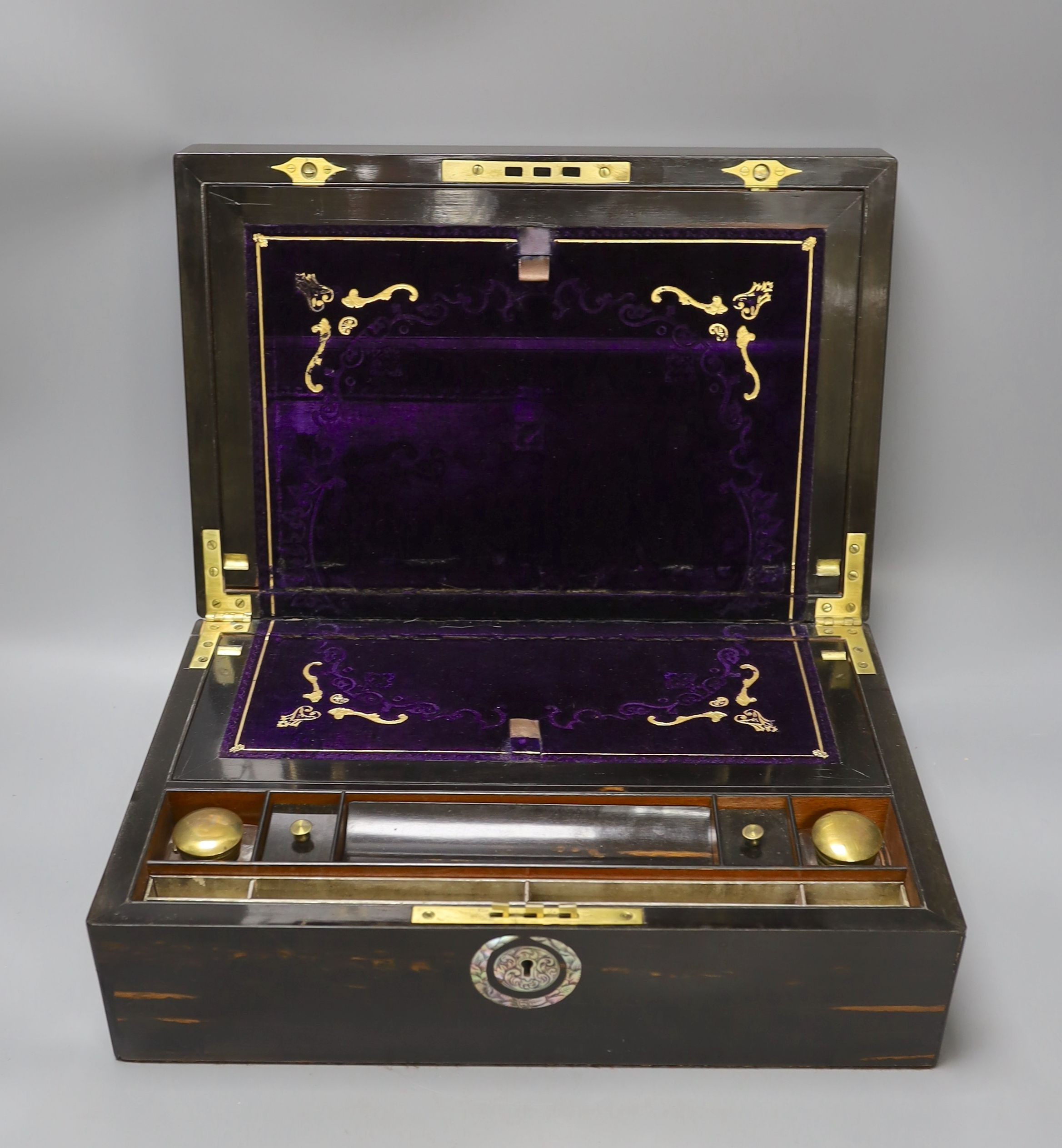 A 19th century coromandel wood writing slope with mother-of-pearl cartouche and original purple tooled velvet interior, 38 cms wide by 25 cms deep.